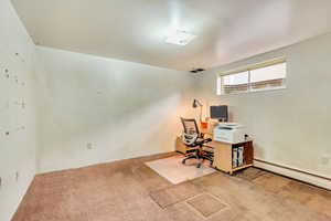 Carpeted home office with baseboard heating