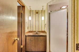 Bathroom with vanity and a shower with door