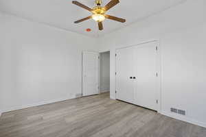 Unfurnished bedroom featuring a closet, ceiling fan, and light hardwood / wood-style flooring