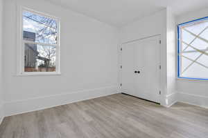 Unfurnished bedroom featuring light wood-type flooring and a closet