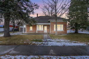 View of front of home featuring covered porch and a lawn