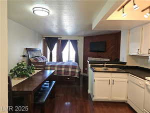 Interior space featuring sink, a textured ceiling, and dark hardwood / wood-style flooring