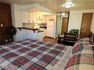 Bedroom featuring white fridge