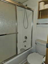 Bathroom with enclosed tub / shower combo and toilet