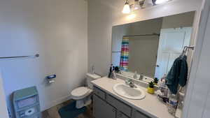 Bathroom with vanity, hardwood / wood-style floors, a shower with curtain, and toilet