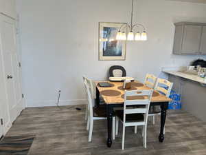 Dining room with dark hardwood / wood-style flooring and a chandelier