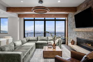 Living room featuring beam ceiling, a fireplace, and wood-type flooring