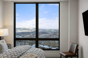 Bedroom featuring multiple windows and a mountain view