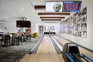 Game room featuring beamed ceiling, wood-type flooring, and bowling