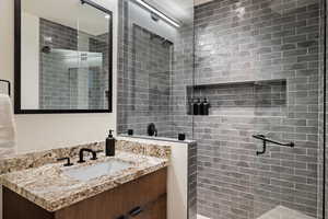 Bathroom with tiled shower and vanity