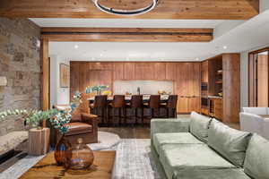 Living room with beamed ceiling, sink, and hardwood / wood-style floors