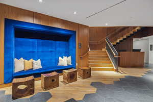 Stairs featuring hardwood / wood-style flooring and wood walls