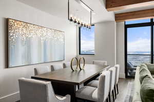 Dining space featuring hardwood / wood-style flooring, an inviting chandelier, and beamed ceiling