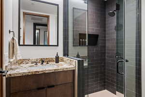 Bathroom featuring vanity and a shower with shower door