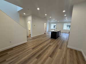 Interior space featuring sink, dark hardwood / wood-style floors, and a center island with sink