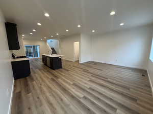 Kitchen featuring sink, an island with sink, and light wood-type flooring