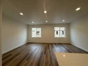 Empty room featuring dark hardwood / wood-style flooring and a wealth of natural light