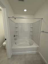 Bathroom featuring shower / bathing tub combination, tile patterned floors, and toilet