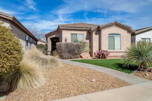 View of front of house featuring a tile roof and stucco siding