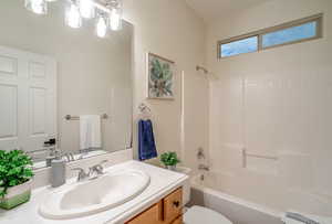 Bathroom with shower / bathtub combination, toilet, and vanity