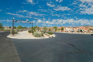 View of street featuring a mountain view, curbs, sidewalks, and street lights