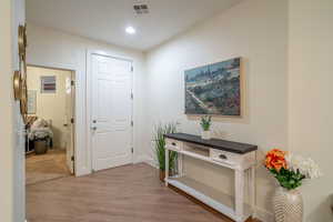 Interior space featuring light wood-type flooring, baseboards, visible vents, and recessed lighting