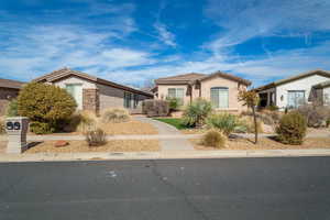 View of front of property featuring stone siding, a tiled roof, and stucco siding