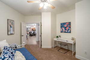 Bedroom featuring ceiling fan, carpet floors, and baseboards