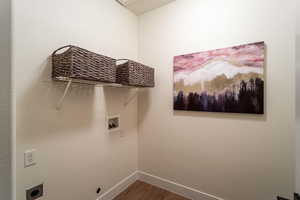 Laundry area with dark wood-style floors, washer hookup, laundry area, and baseboards