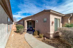 View of side of home featuring fence and stucco siding