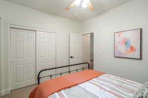 Bedroom featuring a closet, light carpet, and ceiling fan