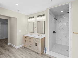 Bathroom with vanity, hardwood / wood-style floors, and a tile shower