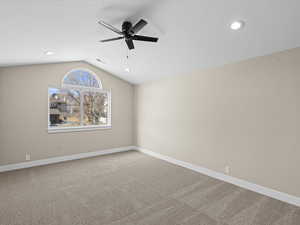 Unfurnished room featuring ceiling fan, carpet flooring, and vaulted ceiling