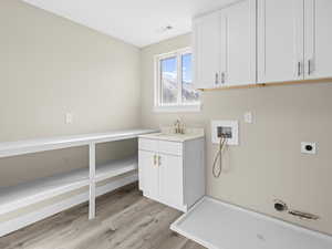 Laundry room with sink, cabinets, washer hookup, hookup for an electric dryer, and light hardwood / wood-style floors