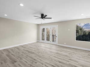 Unfurnished room with ceiling fan and light hardwood / wood-style floors