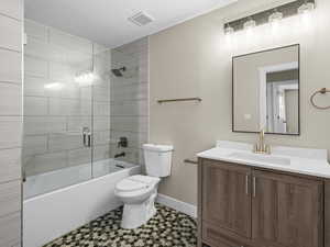 Full bathroom featuring vanity, toilet, and combined bath / shower with glass door