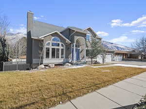 Front of property with a mountain view, a garage, and a front yard