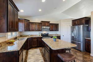 Kitchen with vaulted ceiling, stainless steel appliances, granite countertops & large island