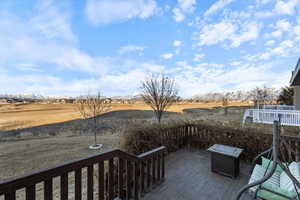 Wooden deck featuring a mountain view nestled on the golf course