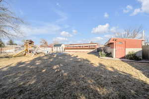 View of yard featuring a out buildings and a playground