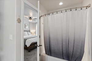 Bathroom featuring shower / tub combo with curtain, and ceiling fan