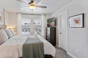 Bedroom featuring ceiling fan, carpet floors, and a large window with natural light