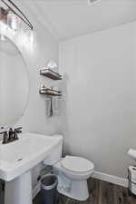 Bathroom with hardwood / wood-style flooring, toilet, and sink