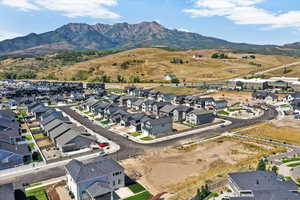 Aerial view of property and surrounding area featuring a mountainous background and nearby suburban area