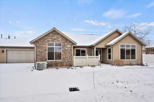 View of front of house with a garage and central air condition unit