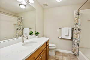 Full bathroom with vanity, tile patterned flooring, toilet, and shower / bathtub combination with curtain