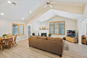 Living room featuring vaulted ceiling, ceiling fan, and light hardwood / wood-style floors