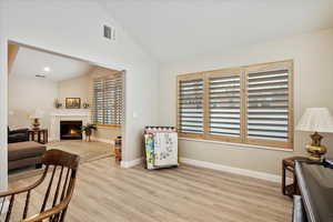 Living area with lofted ceiling and light hardwood / wood-style floors