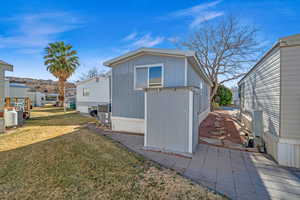 View of side of property featuring central AC and a lawn