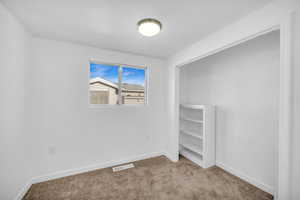 Unfurnished bedroom with light colored carpet